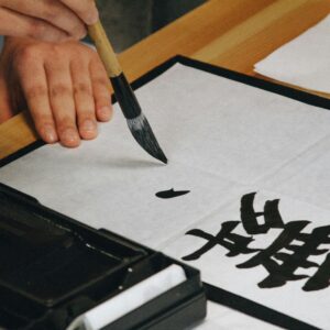 Japanese kanji being written with a brush on paper — learning kanji through writing practice