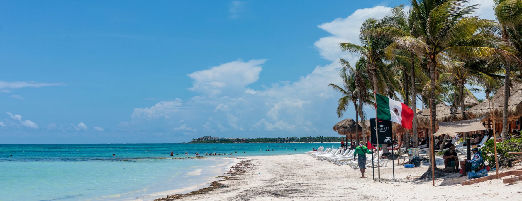 A Mexican Caribbean beach with palm trees and turquoise water — Mexico's federal drinking age applies uniformly to its tourist regions