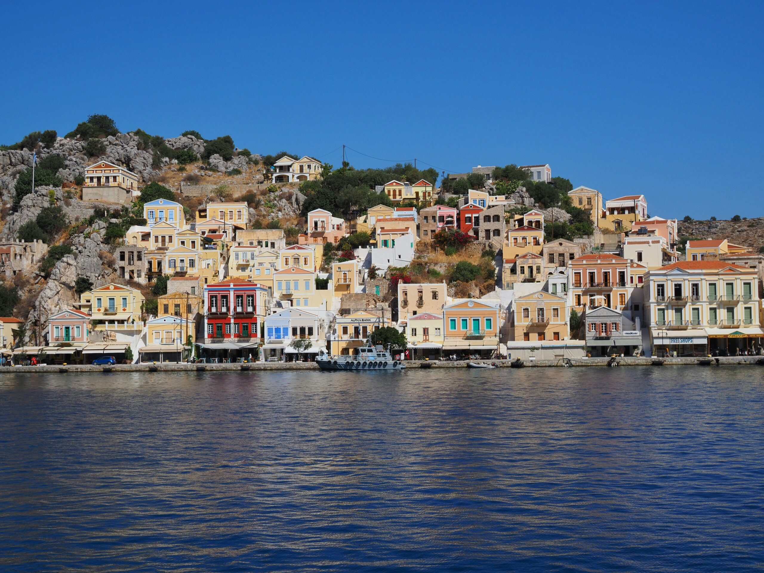 Case neoclassiche colorate di Symi salgono dal porto verso Chorio