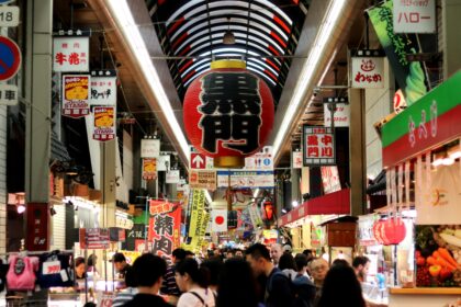 Osaka shopkeeper greeting customer at a Kuromon market stall
