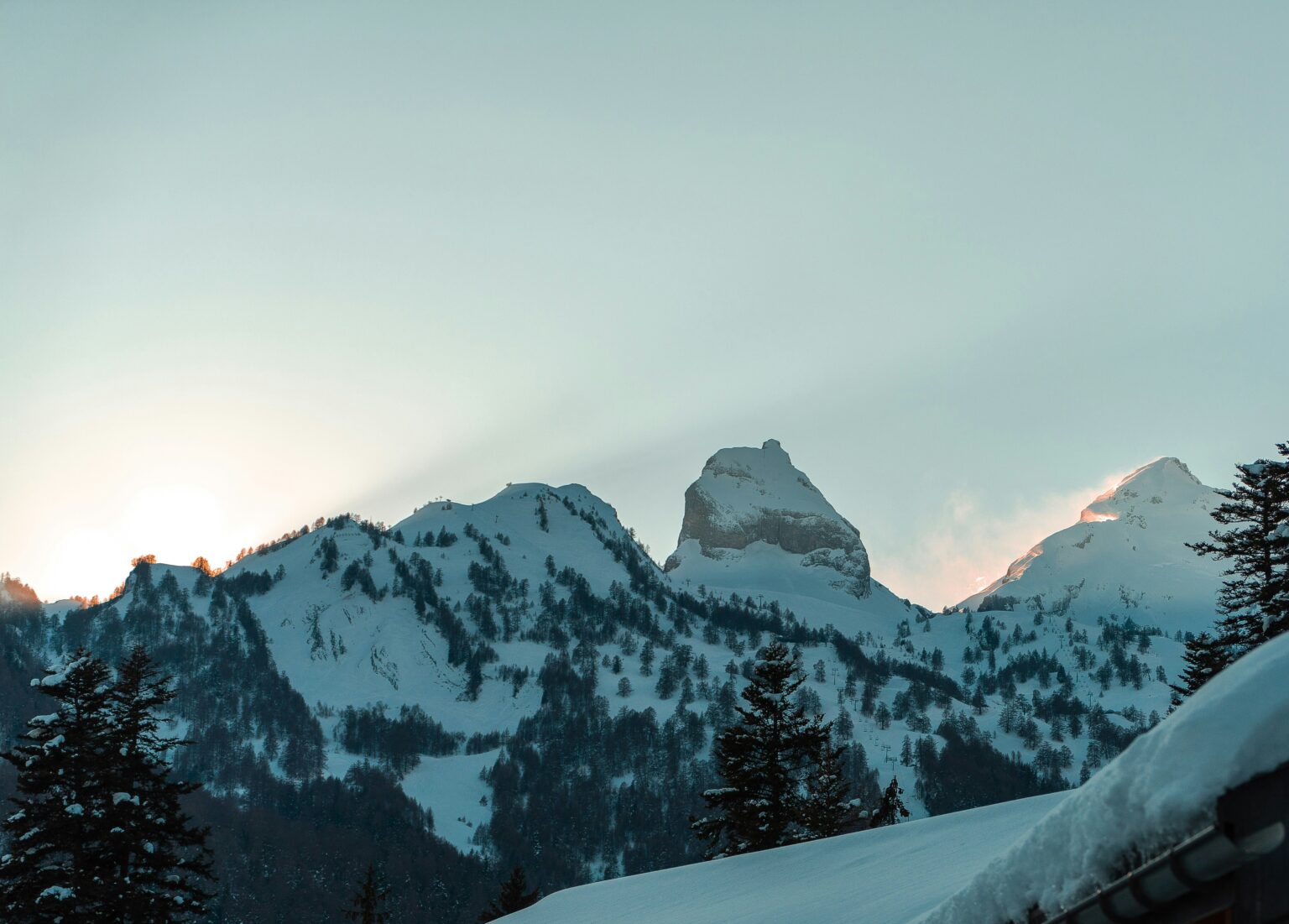 A traditional wooden Swiss chalet in the Bernese Alps with snow-capped mountains behind — the iconic image of Swiss alpine architecture