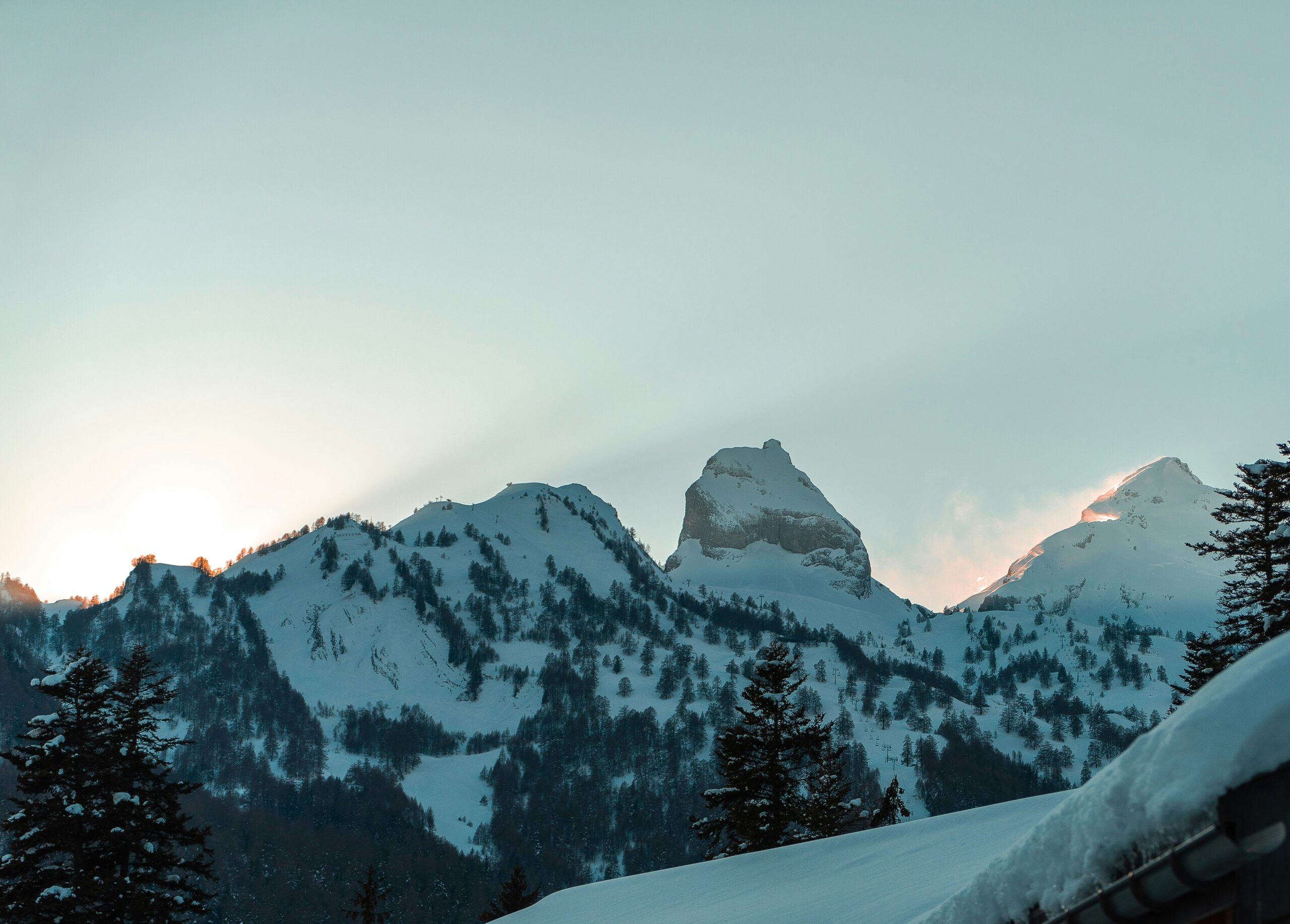A traditional wooden Swiss chalet in the Bernese Alps with snow-capped mountains behind — the iconic image of Swiss alpine architecture