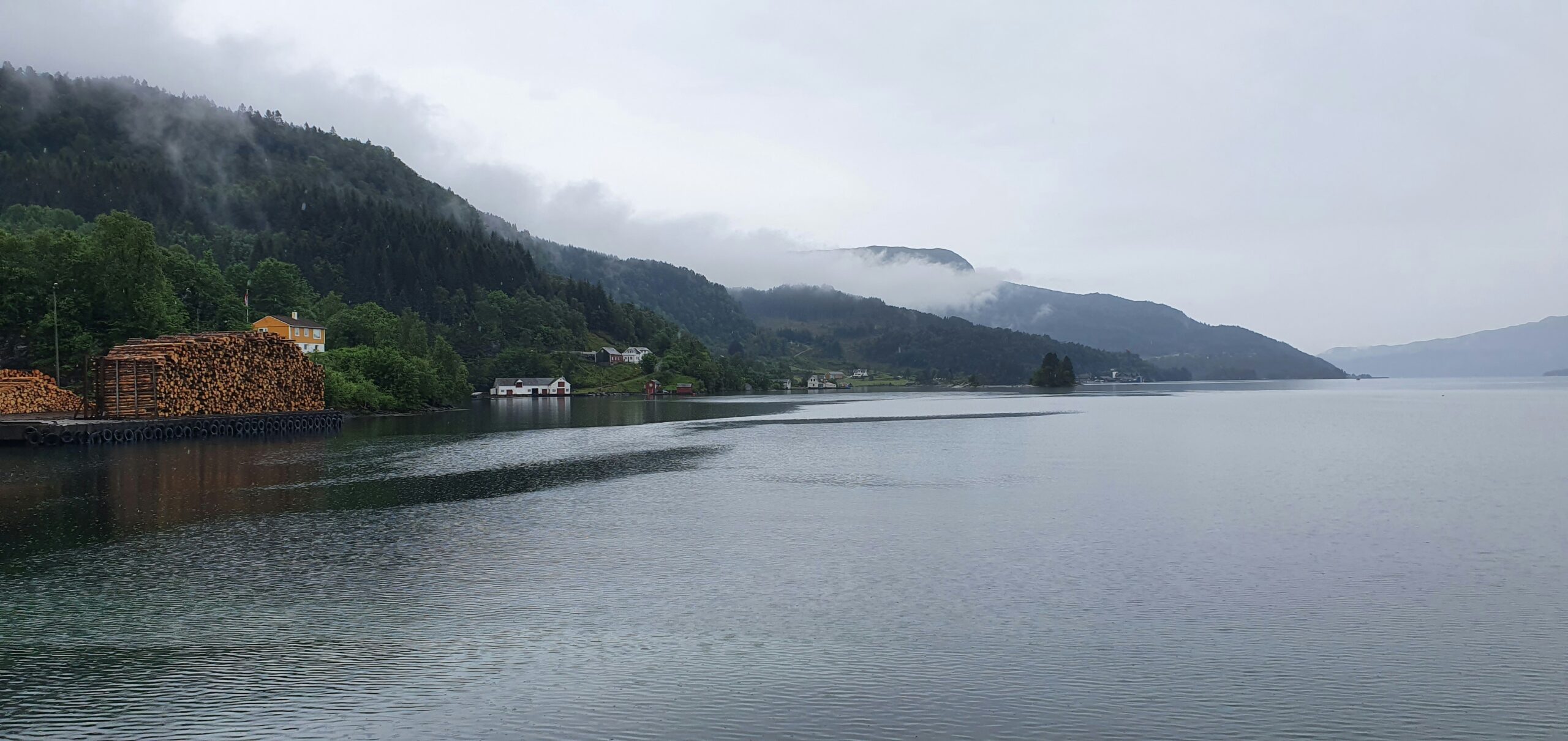 Norwegian fjord with traditional wooden houses and snow-capped mountains — the Scandinavian landscape that shaped its culture