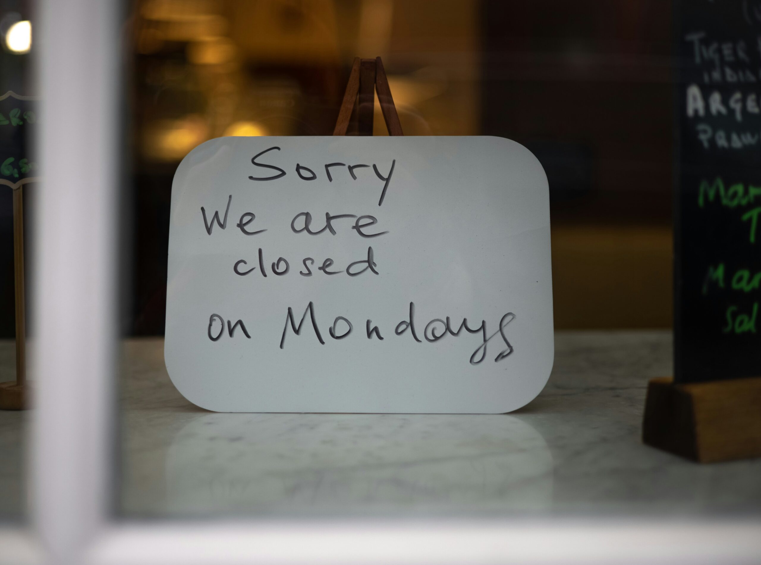 Closed retail storefronts on a quiet European Sunday street — most continental European countries restrict Sunday trading by national law